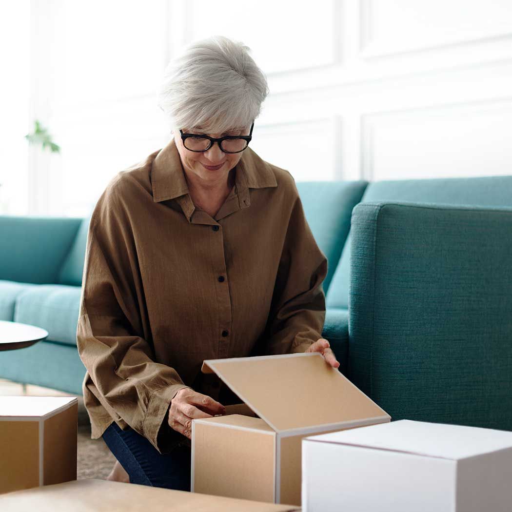 Women unpacking items from brown box