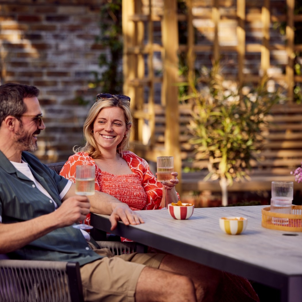 Couple enjoying a drink together in their sunny garden