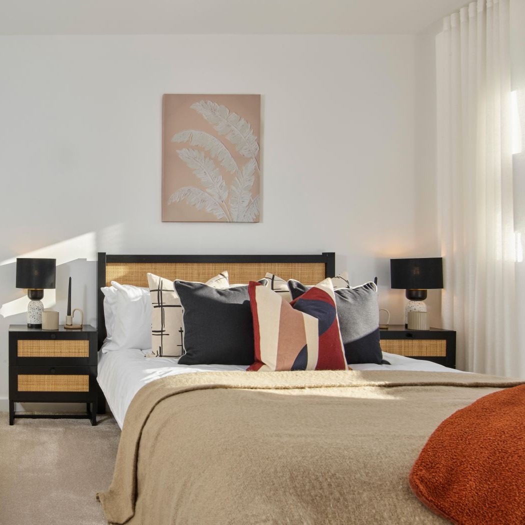 Bright, modern bedroom in an energy‑efficient new home with natural light, neutral décor and contemporary furniture.