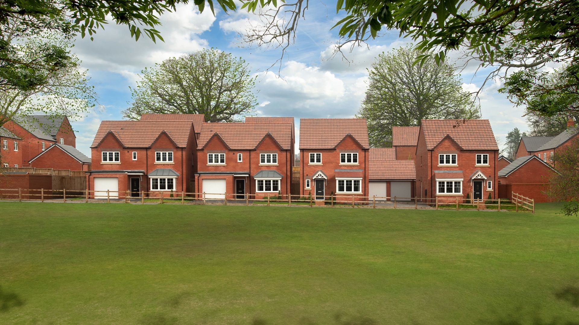 Street scene drone photography taken at Ludlow Green - featuring detached homes overlooking green open space.