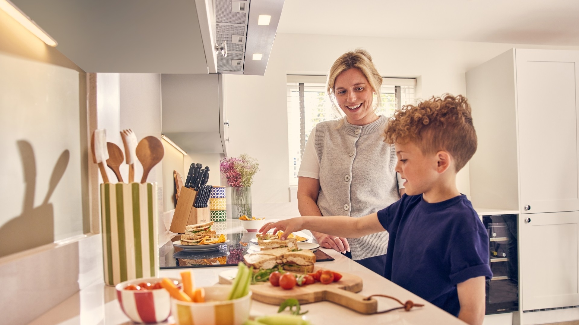 Woman and child cooking together in the kitchen of a new Crest Nicholson home