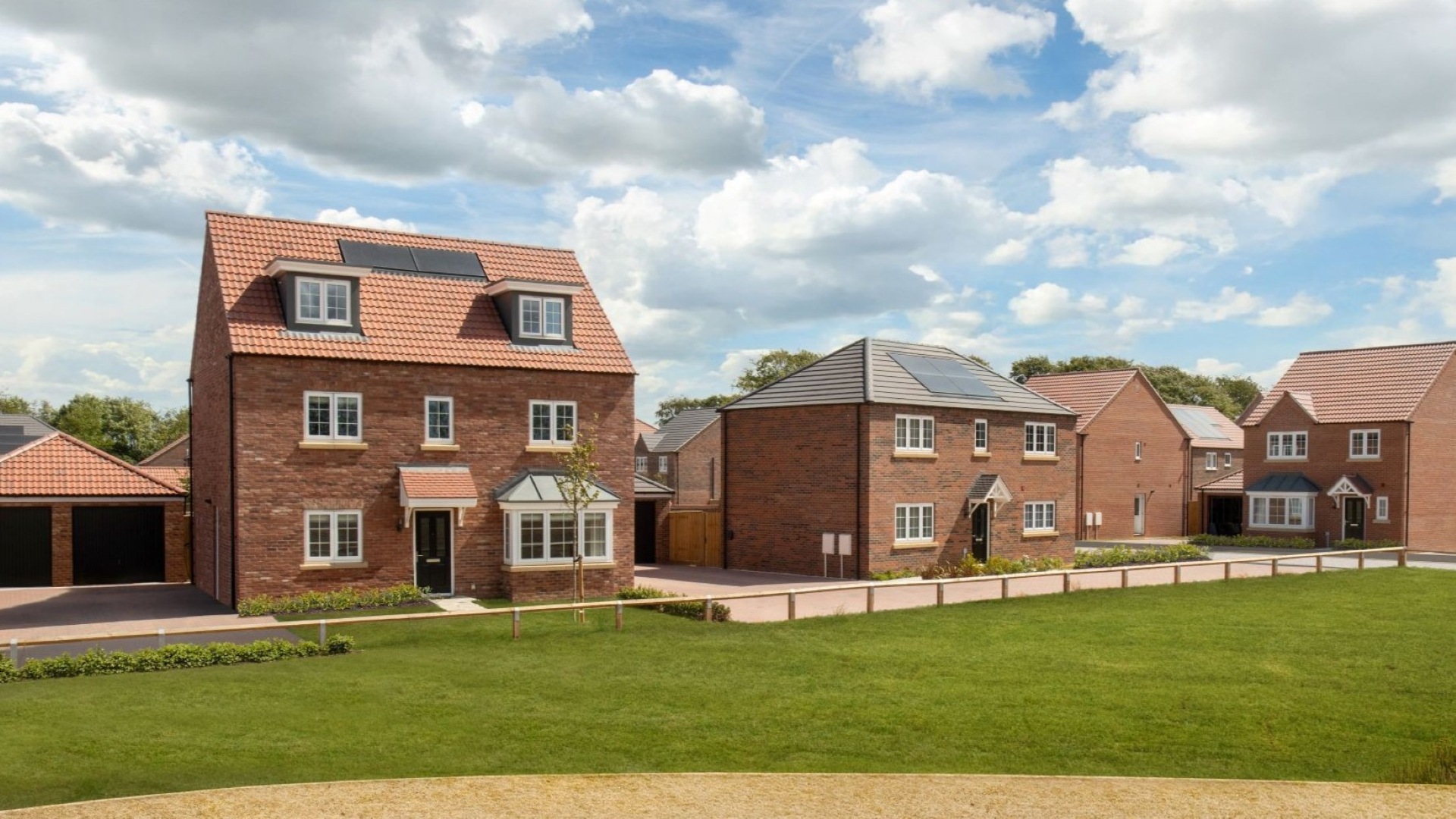 Image showing streetscene of detached homes with green open space in the foreground