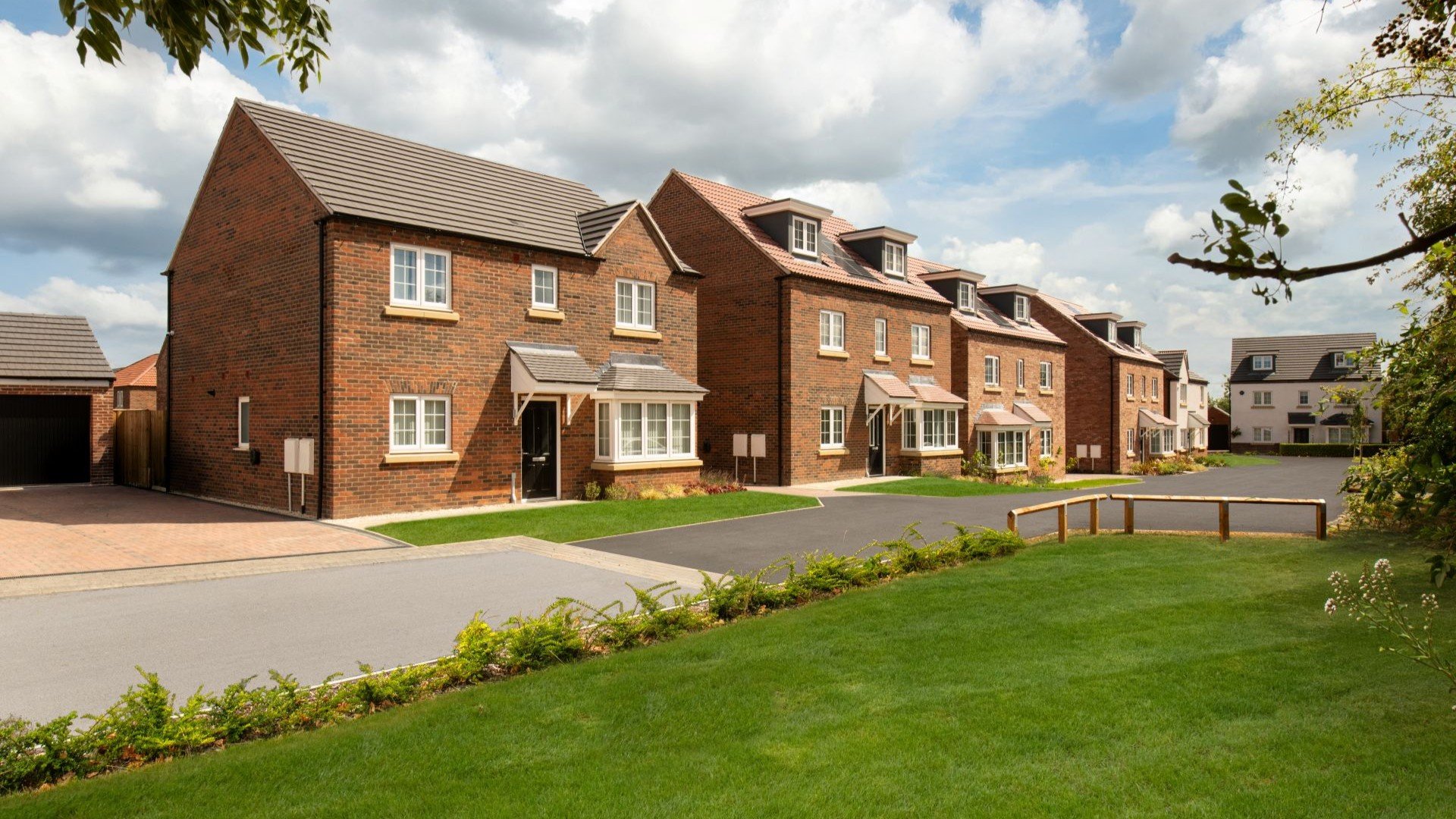 Image showing streetscene of detached homes with green open space in the foreground