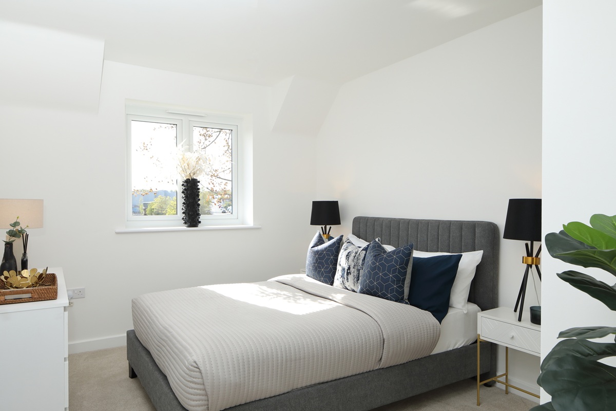 A modern bedroom featuring a bed, bedside tables, lamps and a chest of drawers at Chapel House, Potter's Grange.