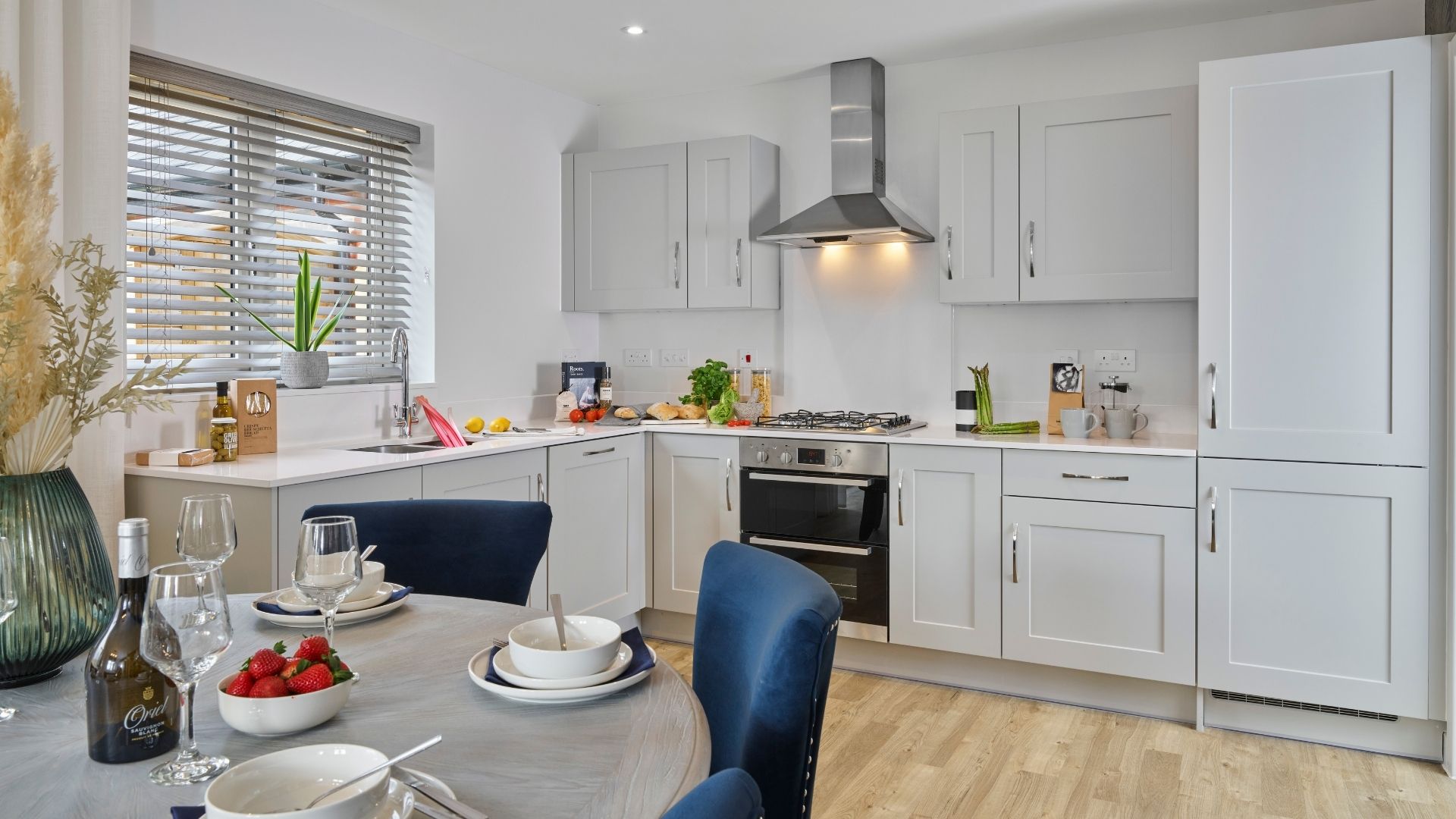 Modern, inviting kitchen/dining room with premium finishes and a beautifully styled dining setting. Taken from the show home at Henley Gate.