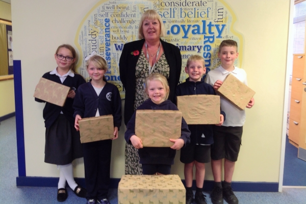 Children and Headteacher holding Christmas gifts