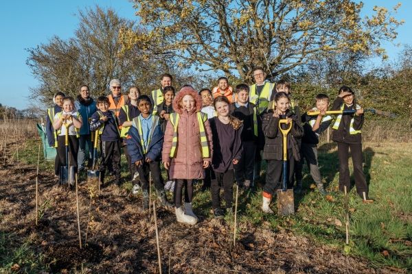 Group of children standing by newly planted trees